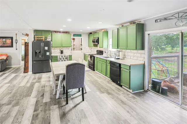 a kitchen with a table chairs refrigerator and furniture