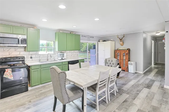a kitchen with a table chairs refrigerator and cabinets