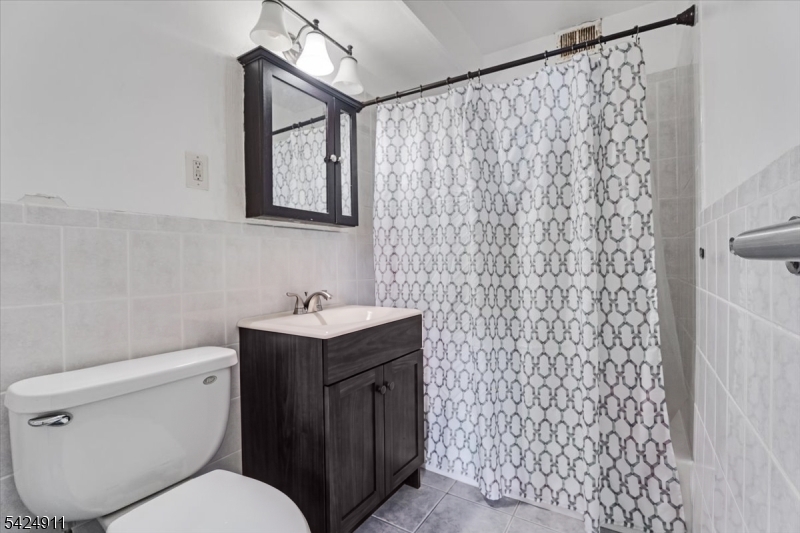 90 Prospect Avenue Hackensack, NJ 07601 - Photo 6 of 21 a bathroom with a toilet sink vanity and mirror