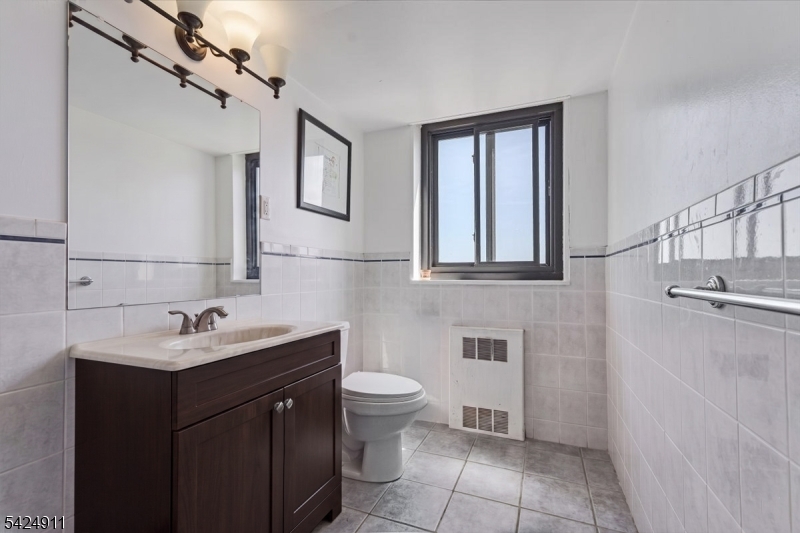 90 Prospect Avenue Hackensack, NJ 07601 - Photo 8 of 21 a bathroom with a sink toilet and mirror