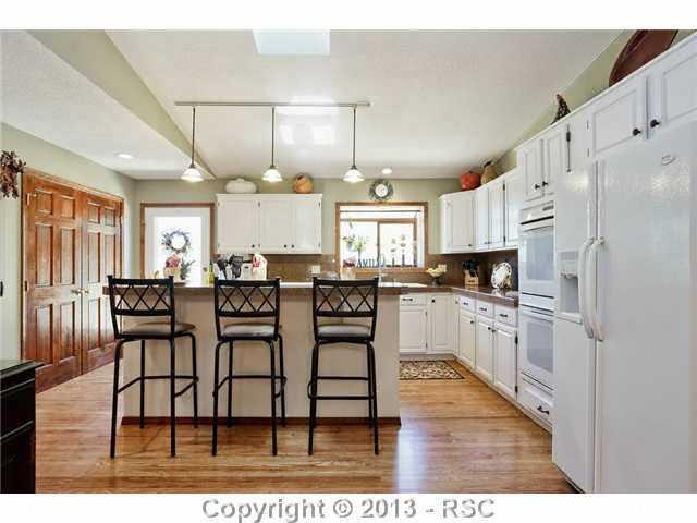 14575 Raton Road Colorado Springs, CO 80921 - Photo 4 of 25 The Kitchen opens to the Dining Room and Great Room. Great for Entertaining! Granite Counters, Eat at Island, Pantry, and Laundry and garage are within proximity. Walkout to the beautifully landscaped backyard and deck.