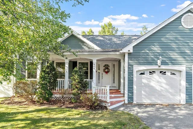 a view of a house with a porch and a large tree