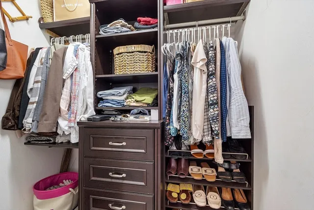 a view of walk in closet with clothes and shoes