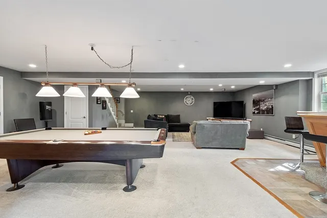 a living room with furniture pool table and a flat screen tv