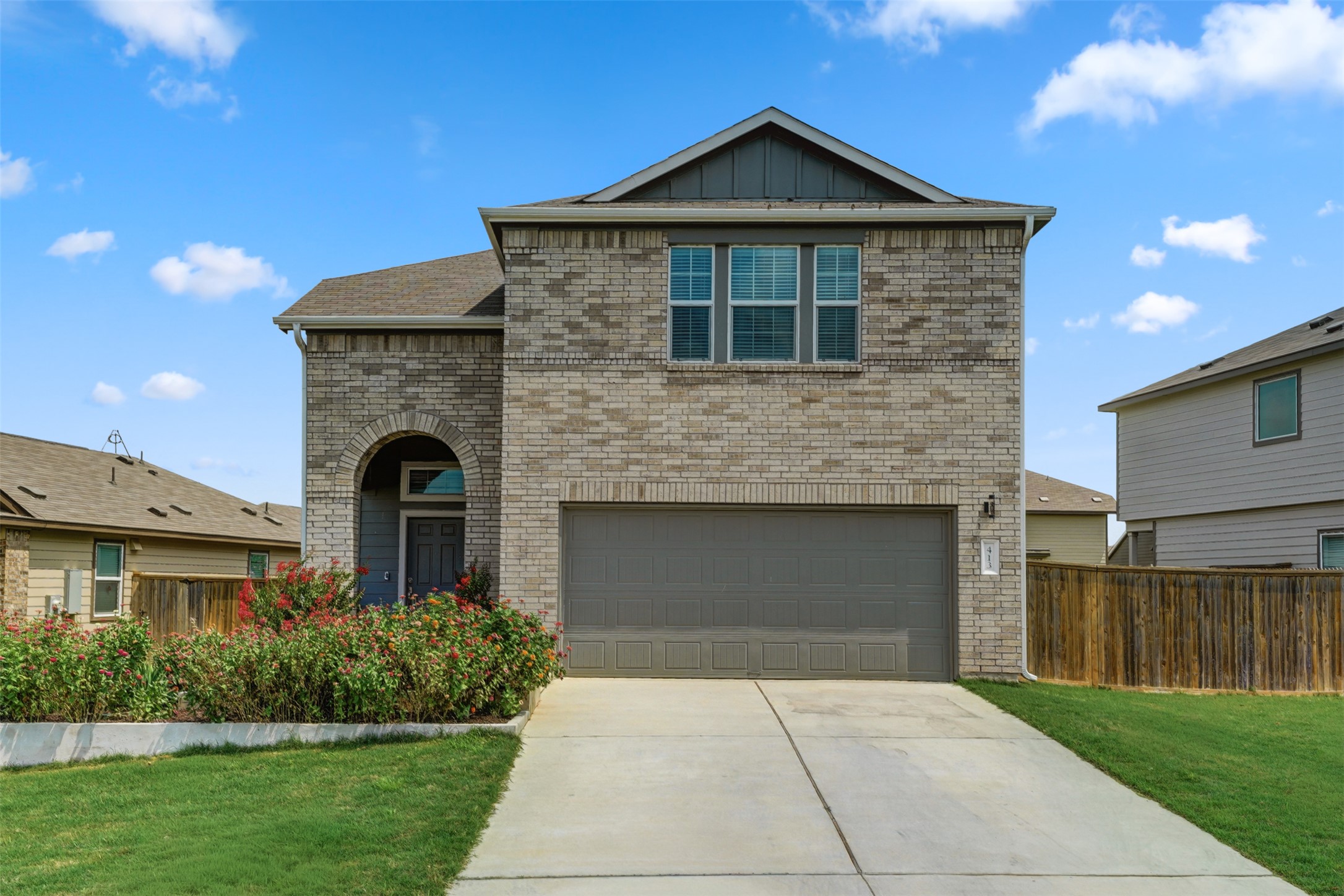 413 Perfect World Loop Jarrell, TX 76537 - Photo 3 of 39 A classic brick facade with an arched entryway and inviting landscaping offers charming curb appeal.