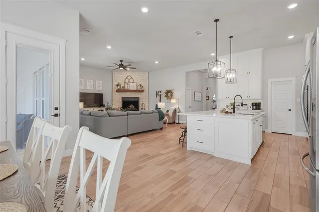 a large white kitchen with lots of counter space wooden floor and appliances