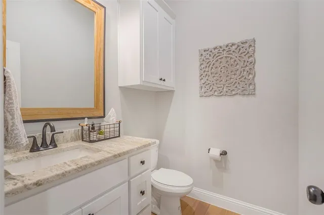 a bathroom with a granite countertop sink toilet and a mirror