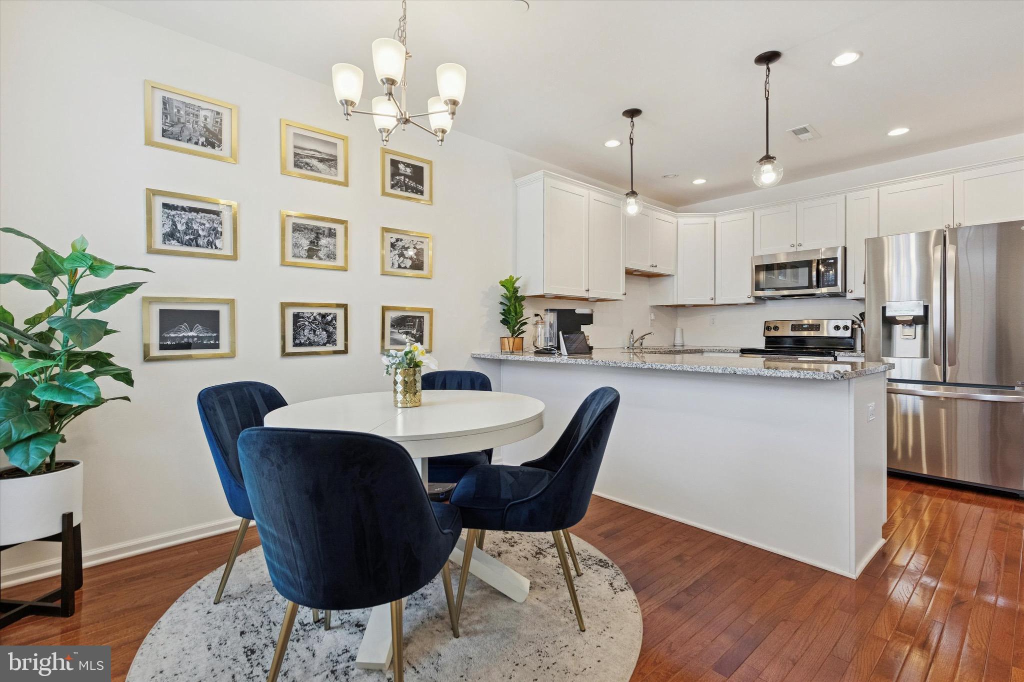 1529 DeKalb Street, Unit 131 Norristown, PA 19401 - Photo 8 of 27 a kitchen with stainless steel appliances kitchen island granite countertop a dining table chairs and a refrigerator