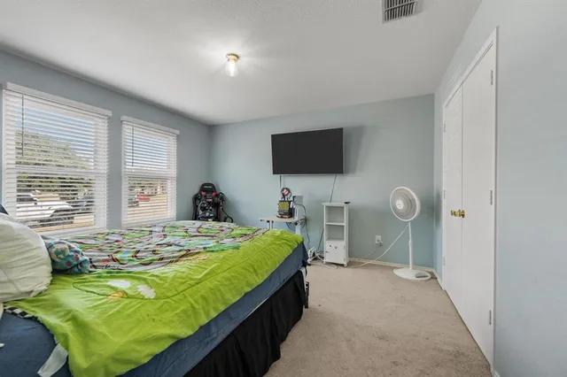 a bed room with a bed television and a large window