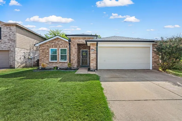 a front view of a house with a garden and yard