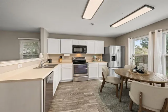 a kitchen with a stove a sink a dining table and chairs