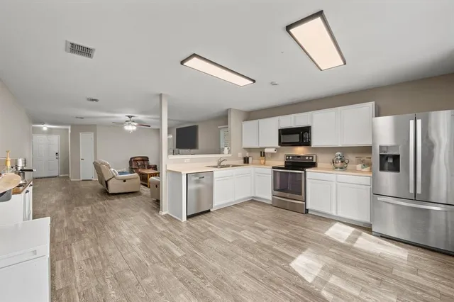 a kitchen with white cabinets and stainless steel appliances