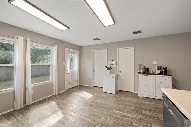 a view of a kitchen with wooden floor and electronic appliances