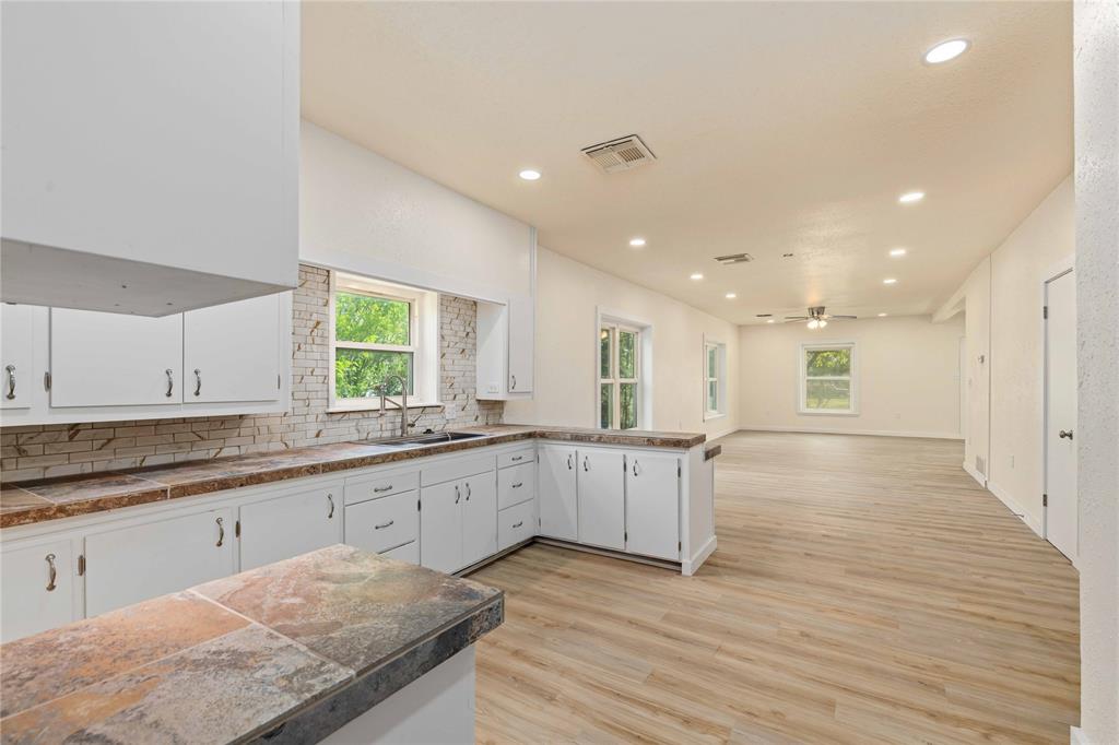 516 South Pecos Street Coleman, TX 76834 - Photo 11 of 32 a large kitchen with granite countertop a large counter top and sink