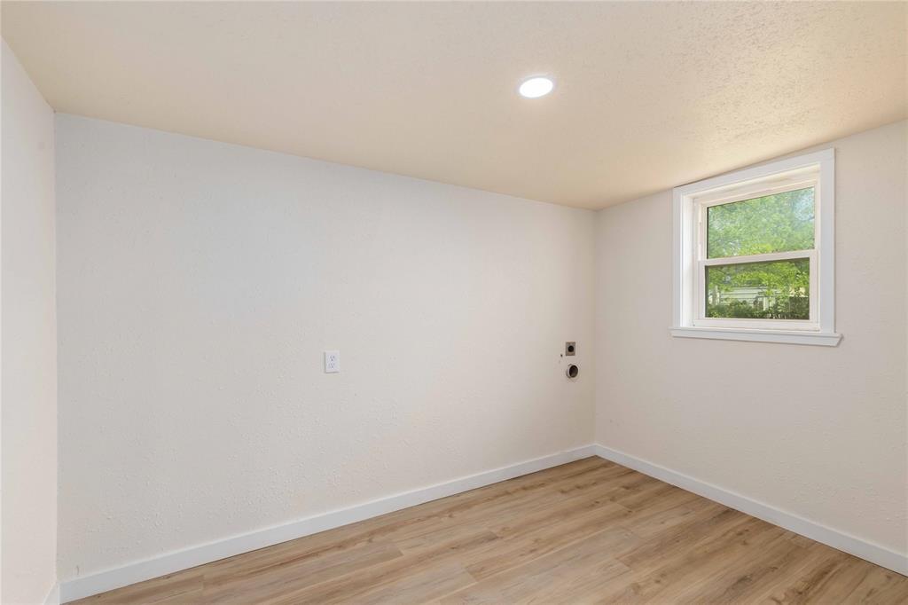 516 South Pecos Street Coleman, TX 76834 - Photo 12 of 32 an empty room with wooden floor and windows