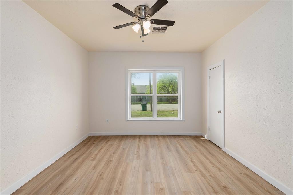 516 South Pecos Street Coleman, TX 76834 - Photo 15 of 32 an empty room with a window and a ceiling fan
