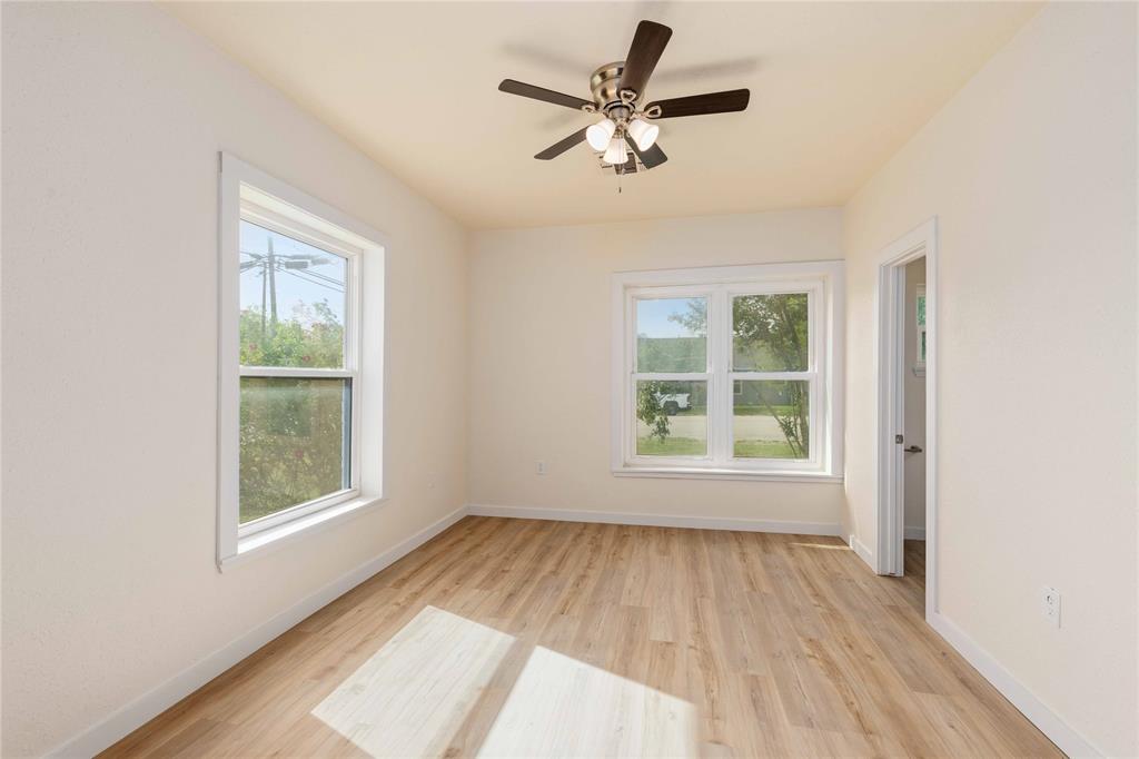 516 South Pecos Street Coleman, TX 76834 - Photo 16 of 32 a view of empty room with wooden floor and fan