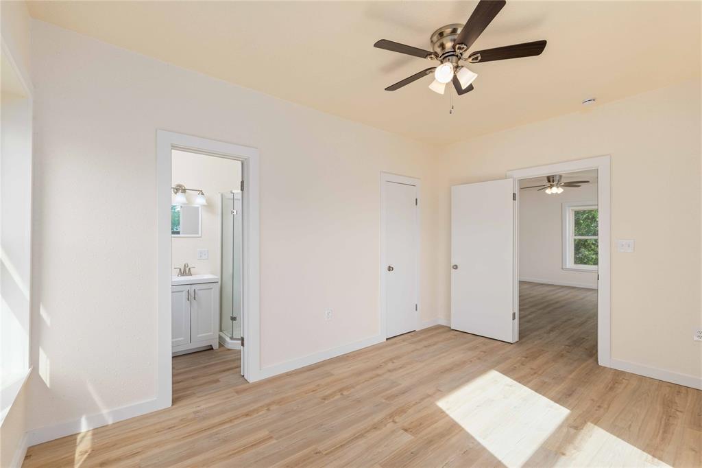 516 South Pecos Street Coleman, TX 76834 - Photo 17 of 32 an empty room with wooden floor and ceiling fan