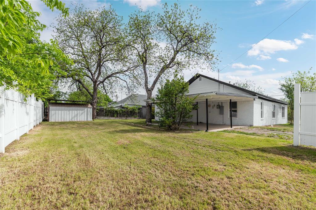 516 South Pecos Street Coleman, TX 76834 - Photo 31 of 32 a yellow house with trees in front of it
