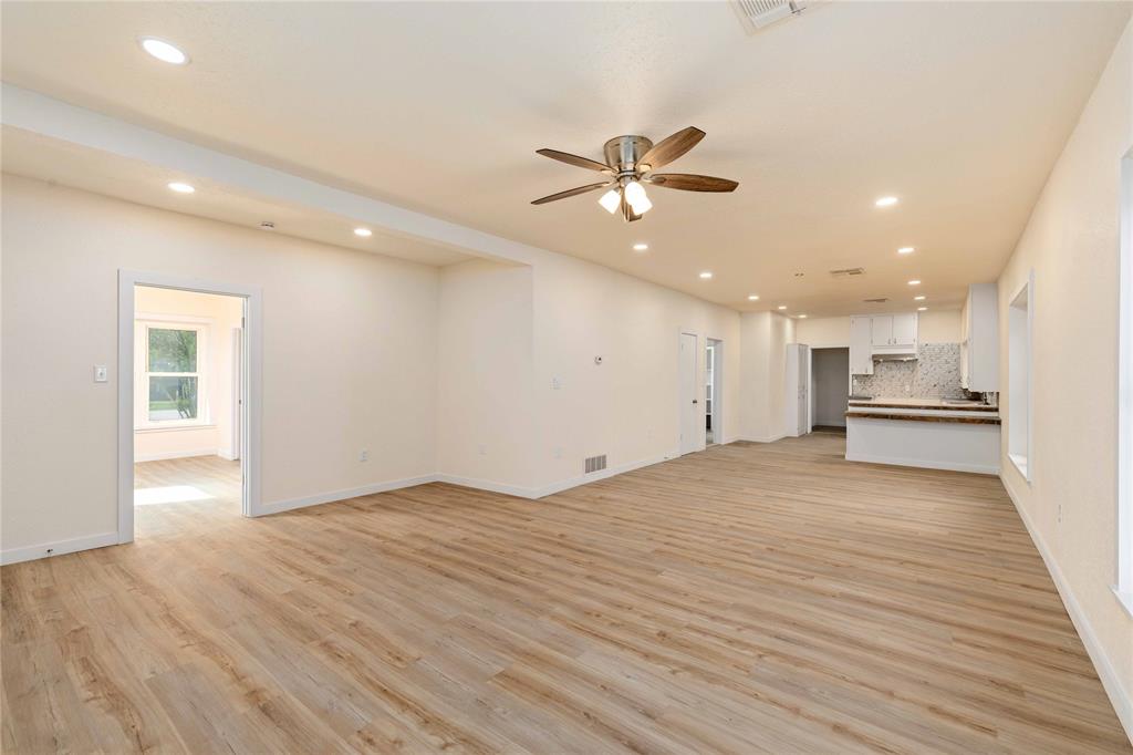 516 South Pecos Street Coleman, TX 76834 - Photo 5 of 32 a view of kitchen and empty room with wooden floor
