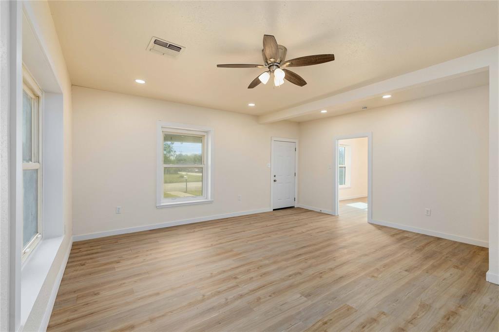 516 South Pecos Street Coleman, TX 76834 - Photo 6 of 32 a view of an empty room with wooden floor and a window