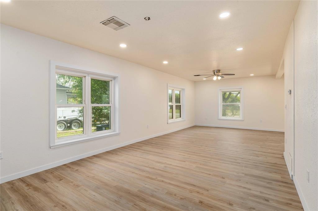 516 South Pecos Street Coleman, TX 76834 - Photo 8 of 32 an empty room with wooden floor and windows