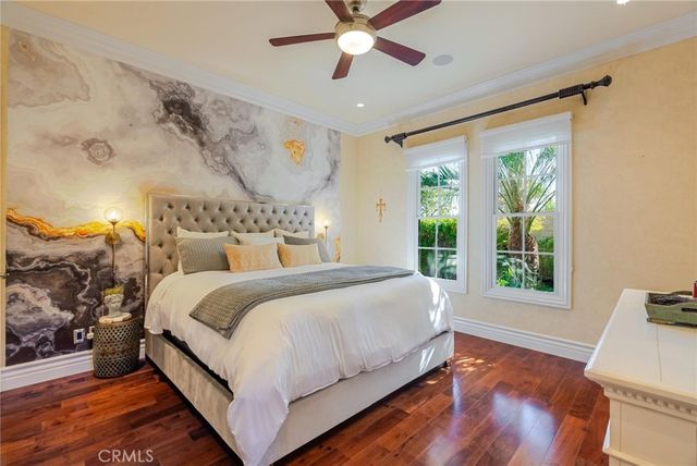 a bedroom with a bed window and a flat screen tv