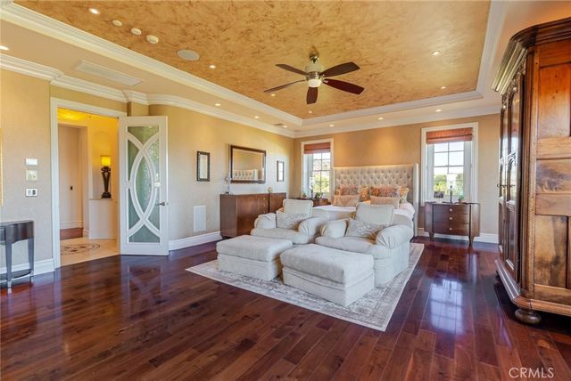 a bedroom with a large bed a flat tv screen and dresser