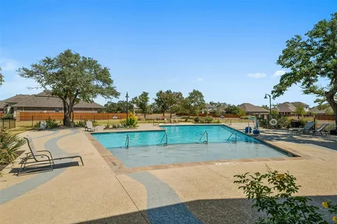 a view of a swimming pool with a lawn chairs and a fire pit