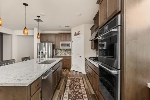 a kitchen with stainless steel appliances granite countertop a sink and stove