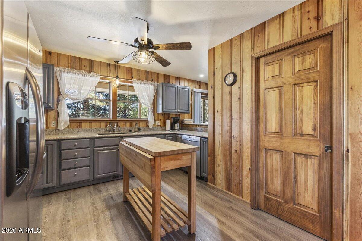 24 County Road 2065 Alpine, AZ 85920 - Photo 8 of 35 a kitchen with stainless steel appliances granite countertop a refrigerator a sink dishwasher a dining table and chairs with wooden floor