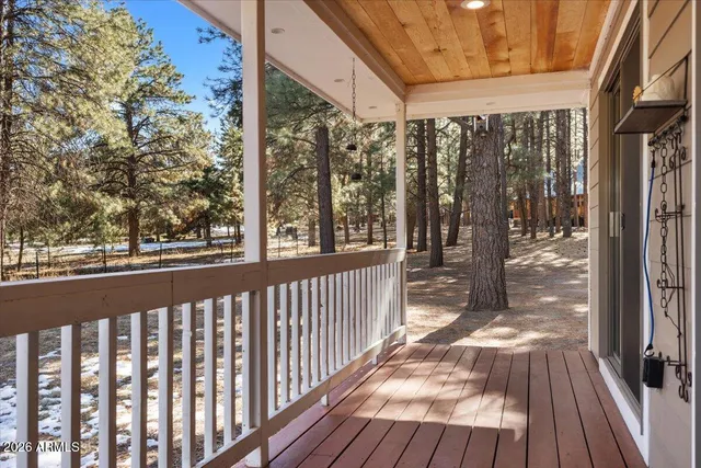 a view of a porch with wooden floor and floor to ceiling window