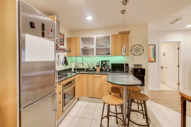 a kitchen with stainless steel appliances granite countertop a refrigerator and a stove top oven