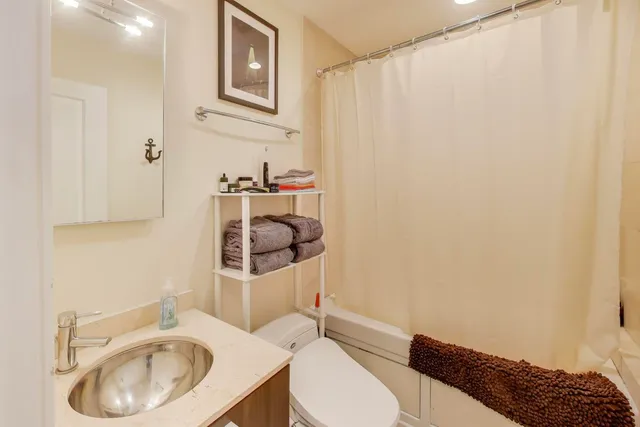 a bathroom with a sink a toilet and a mirror