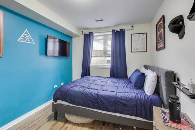 a bedroom with a bed and wooden floor