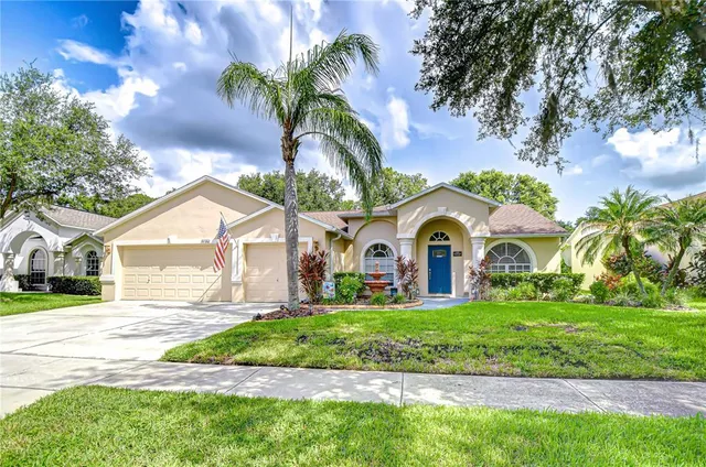 a front view of a house with a garden and trees