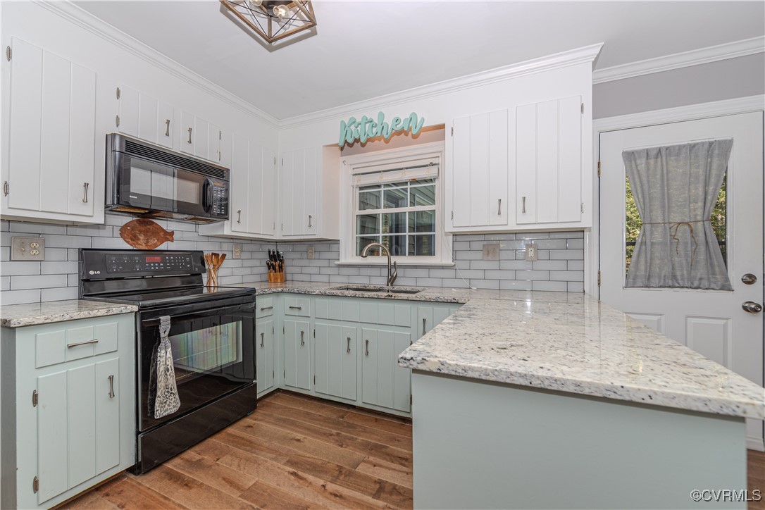 Kitchen with ornamental molding, white cabinetry,