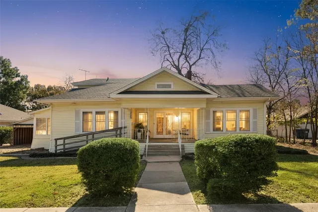 a front view of a house with swimming pool and porch with furniture