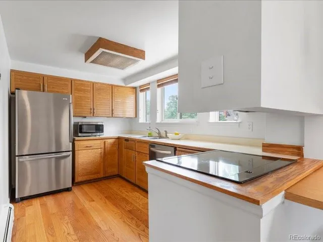 a kitchen with a refrigerator sink and cabinets