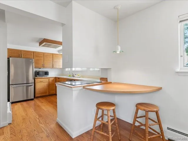 a kitchen with stainless steel appliances white cabinets and wooden floor