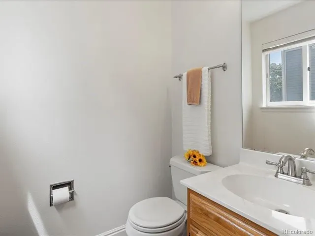 a bathroom with a sink vanity mirror and toilet