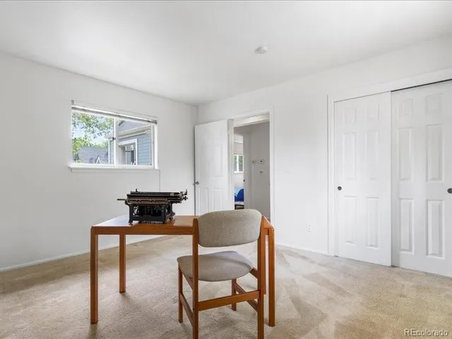 a living room with furniture and a painting on the wall