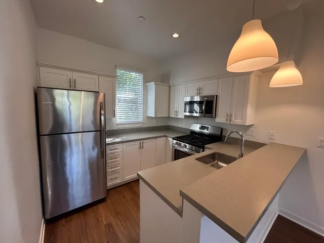 a kitchen with a refrigerator sink and cabinets