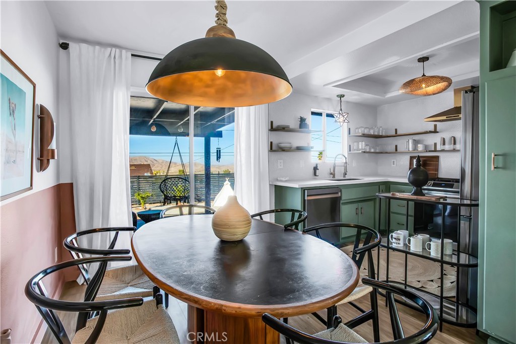 60670 Pueblo Trail Joshua Tree, CA 92252 - Photo 4 of 14 a kitchen with stainless steel appliances a dining table and chairs