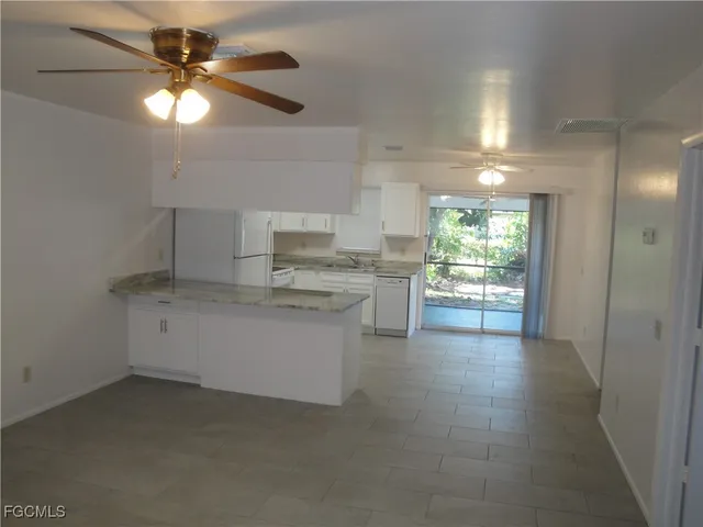 a kitchen with a refrigerator and white cabinets