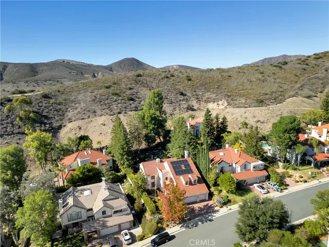an aerial view of a house with a mountain