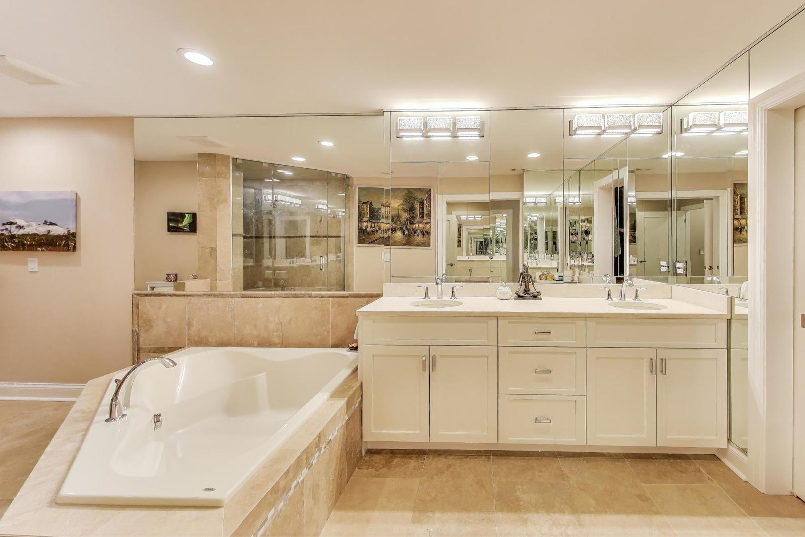3810 Mission Hills Road, Unit 202 Northbrook, IL 60062 - Photo 14 of 25 a bathroom with a tub a double vanity sink and mirror