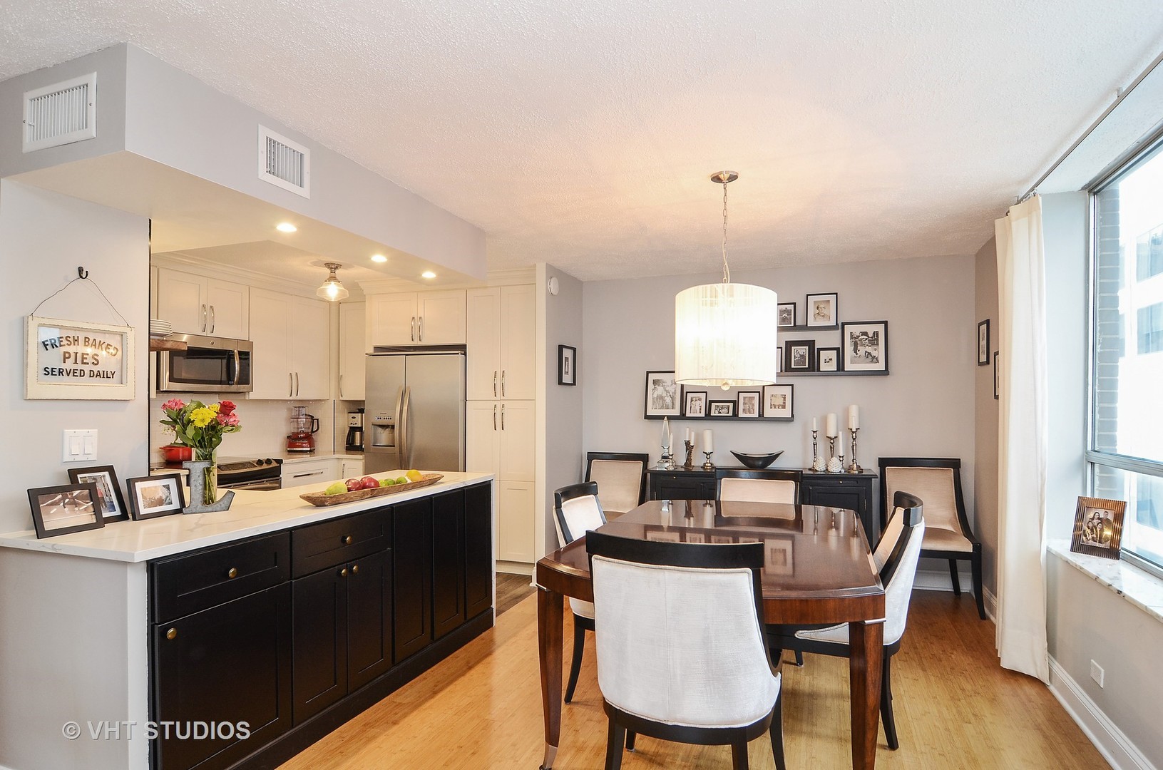 201 East Chestnut Street, Unit 20A Chicago, IL 60611 - Photo 5 of 13 a kitchen with a dining table chairs and white cabinets