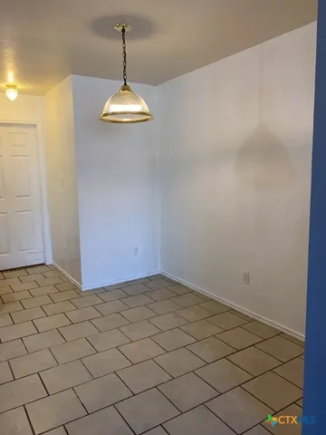 a view of a room with a chandelier fan and wooden floor