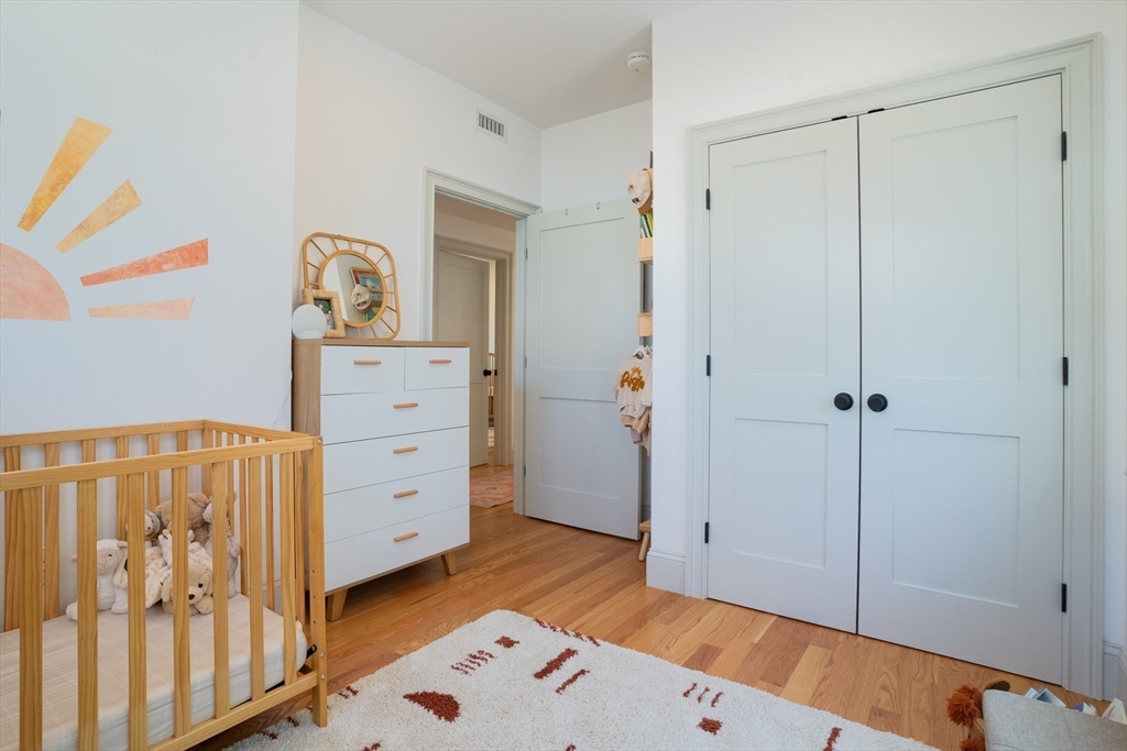 16 Church Street Boston, MA 02122 - Photo 12 of 23 a view of a bedroom with baby crib and dresser